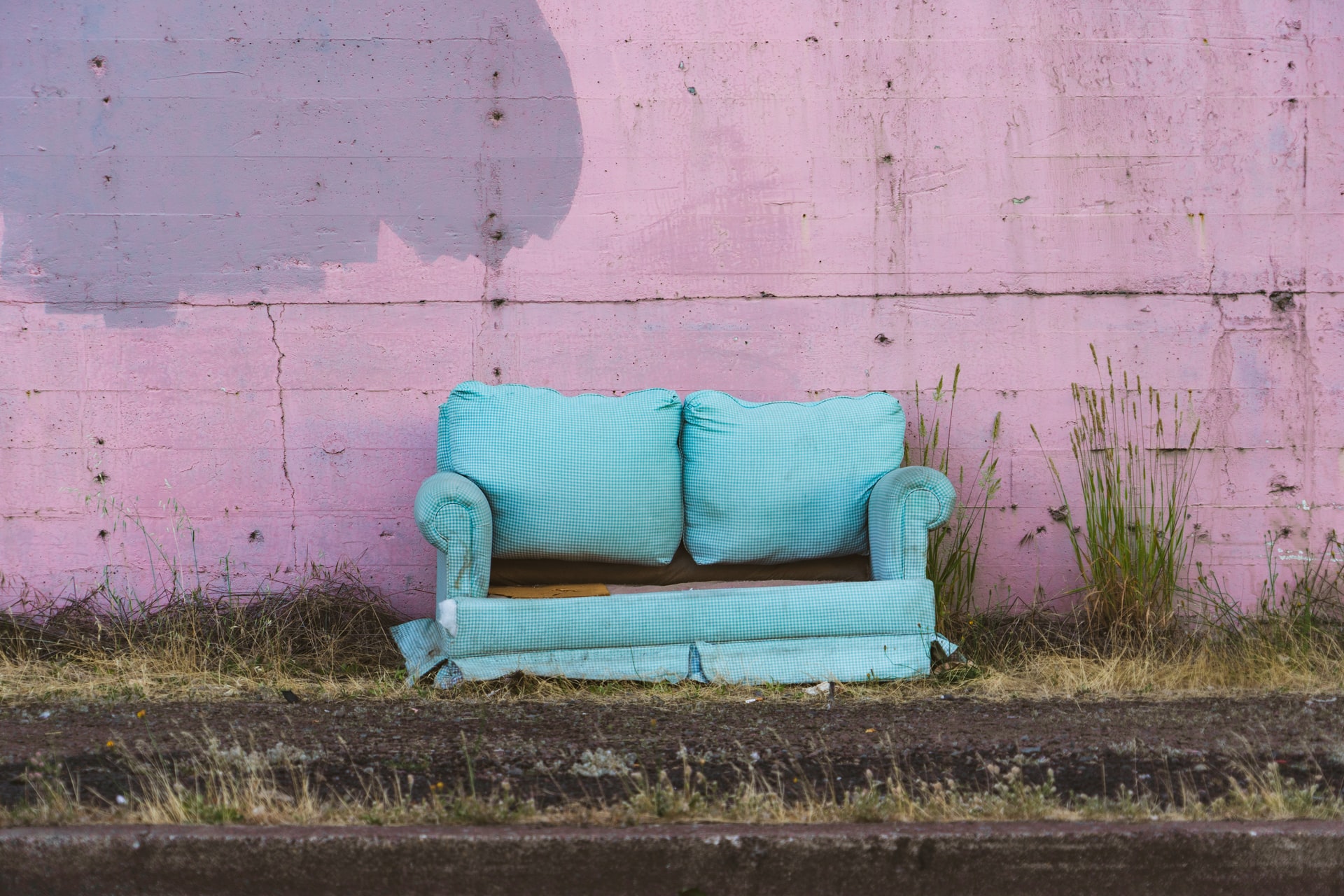 old blue sofa against pink wall