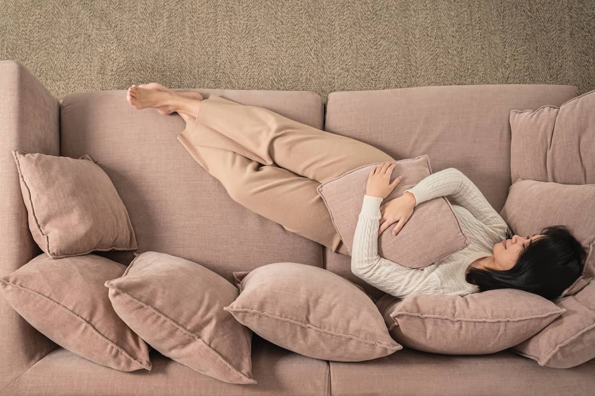 A girl relaxing on a dusty pink sofa.